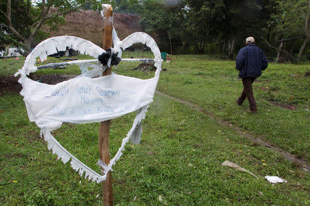 Man walks past a heart-shaped sign with the name of Jakelin, a 7-year-old girl who died in U.S. custody, outside her house in Raxruha, Guatemala December 15, 2018. REUTERS/Josue Decavele