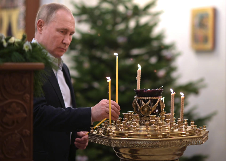 Russian President Vladimir Putin lights a candle during the Orthodox Christmas Liturgy in the Church of the Image of the Saviour Made Without Hands in Novo-Ogaryovo, outside Moscow, Russia, late Thursday, Jan. 6, 2022. Orthodox Christians celebrate Christmas on Jan. 7, in accordance with the Julian calendar. (Alexei Nikolsky/Sputnik, Kremlin Pool Photo via AP)