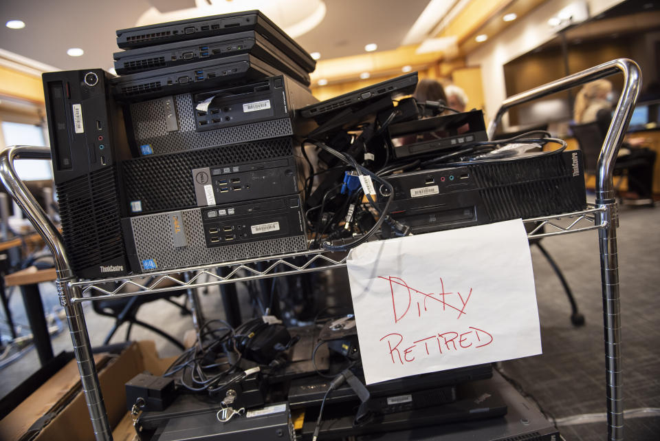 In this photo provided by the University of Vermont Health Network, computers impacted by a cyberattack at the University of Vermont Medical Center in Burlington, Vt., wait to be replaced on Friday, Nov. 20, 2020. After the Oct. 28 attack forced a shutdown of the hospital’s electronic medical records and other key systems, the IT department, with support from the Vermont National Guard’s cyber team, scanned thousands of computers for malware and replaced machines for hospital staff. (Ryan Mercer/University of Vermont Health Network via AP)