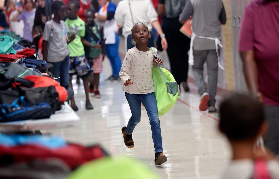 Peythie Chuol runs to her family with her new backpack during Refugee Back to School Night at Granite Park Junior High in South Salt Lake on Monday, Aug. 7, 2023. | Kristin Murphy, Deseret News