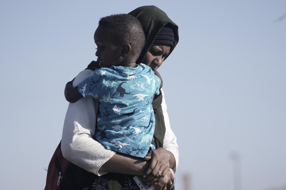 FILE - A Sudanese evacuee carries her son as they disembark from the USNS Brunswick at Jeddah port, Saudi Arabia, May 4, 2023. Some 110 million people around the world have had to flee their homes because of conflict, persecution, or human rights violations, the U.N. High Commissioner for Refugees says. The war in Sudan, which has displaced nearly 2 million people since April, is but the latest in a long list of crises that has led to the record-breaking figure. (AP Photo/Amr Nabil, File)