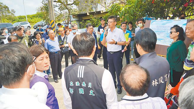 水利署規畫在台南市佳里區安西里興建海水淡化廠受水池，數十名自救會成員15日向水利署官員抗議，水利署副署長黃宏莆（中持麥克風）向自救會成員溝通說明。（寶智華攝）