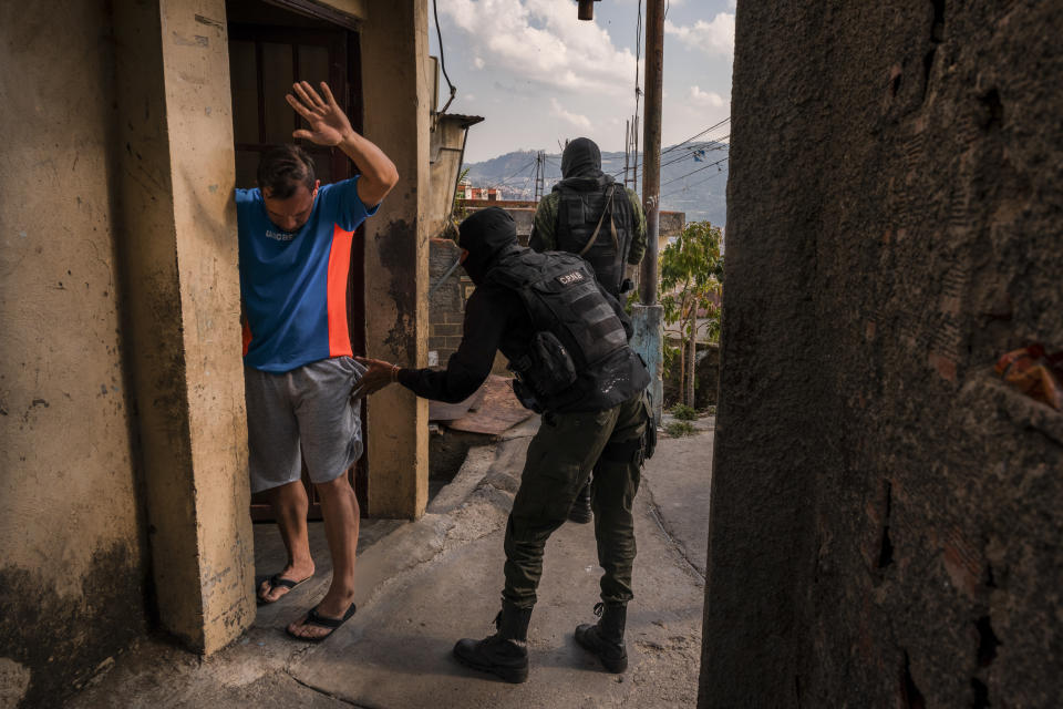 Agentes de policía revisaban a un hombre en un barrio controlado por un grupo armado en Petare, Venezuela. (Adriana Loureiro Fernandez/The New York Times)
