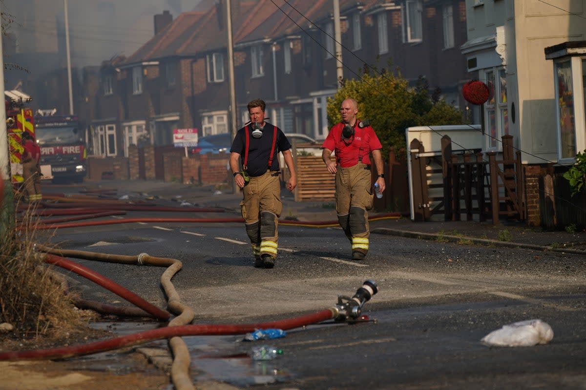 Firefighters at the scene of a blaze in the village of Wennington during a heatwave in July 2022 (PA)