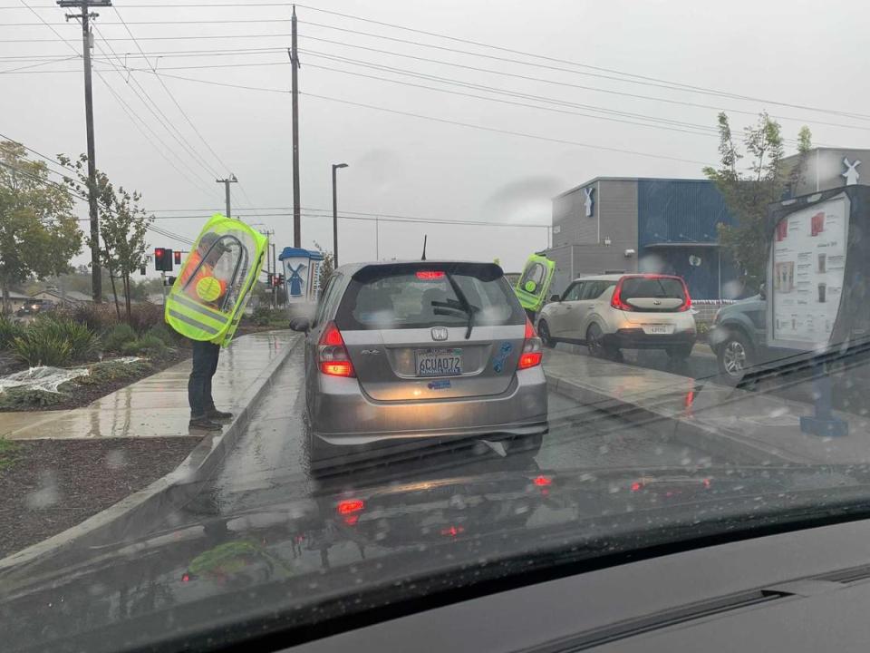 Workers at Dutch Bros. coffee on El Camino and Eastern avenues take orders on Sunday, Oct. 24, 2021. The drive-through provide its outdoor order-takers with a special plastic enclosure pod to stay dry.