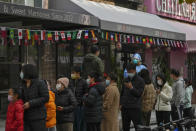 ARCHIVO - Personas con mascarilla hacen fila el 22 de noviembre de 2022 para realizarse pruebas diagnósticas de COVID-19 de rutina cerca de locales comerciales cerrados de Beijing como parte de las medidas impuestas para evitar la propagación del COVID. (AP Foto/Andy Wong, Archivo)