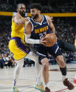 Denver Nuggets guard Jamal Murray, right, drives to the basket as Los Angeles Lakers guard Spencer Dinwiddie, left, defends in the first half of Game 5 of an NBA basketball first-round playoff series Monday, April 29, 2024, in Denver. (AP Photo/David Zalubowski)