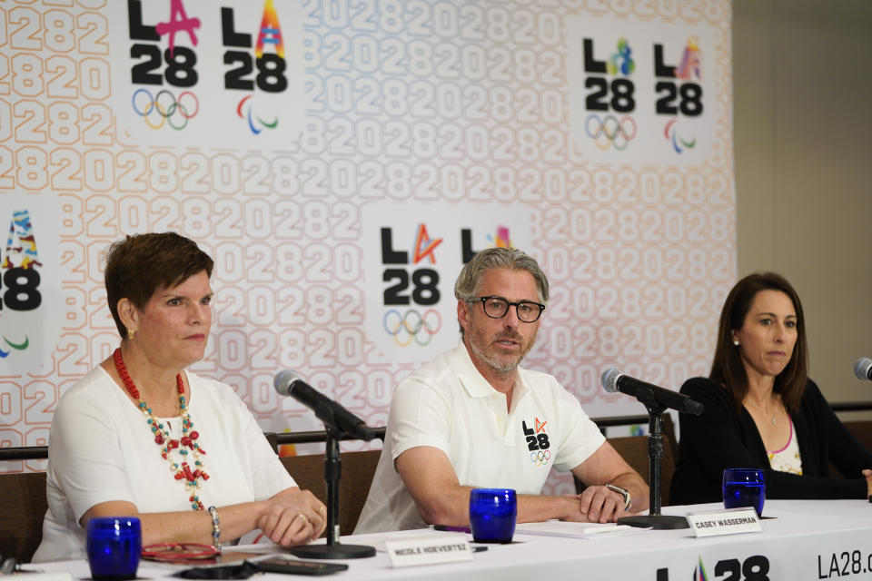 LA28 Chairperson Casey Wasserman, center, speaks as he is joined by Nicole Hoevertsz, IOC member and LA28 coordination commission chair, left, and Janet Evans, LA28 chief athlete officer and 5-time Olympic medalist, during a news conference, Thursday, Sept. 15, 2022, in Los Angeles, updating their progress in planning the 2028 Los Angeles Olympics games. (AP Photo/Jae C. Hong)
