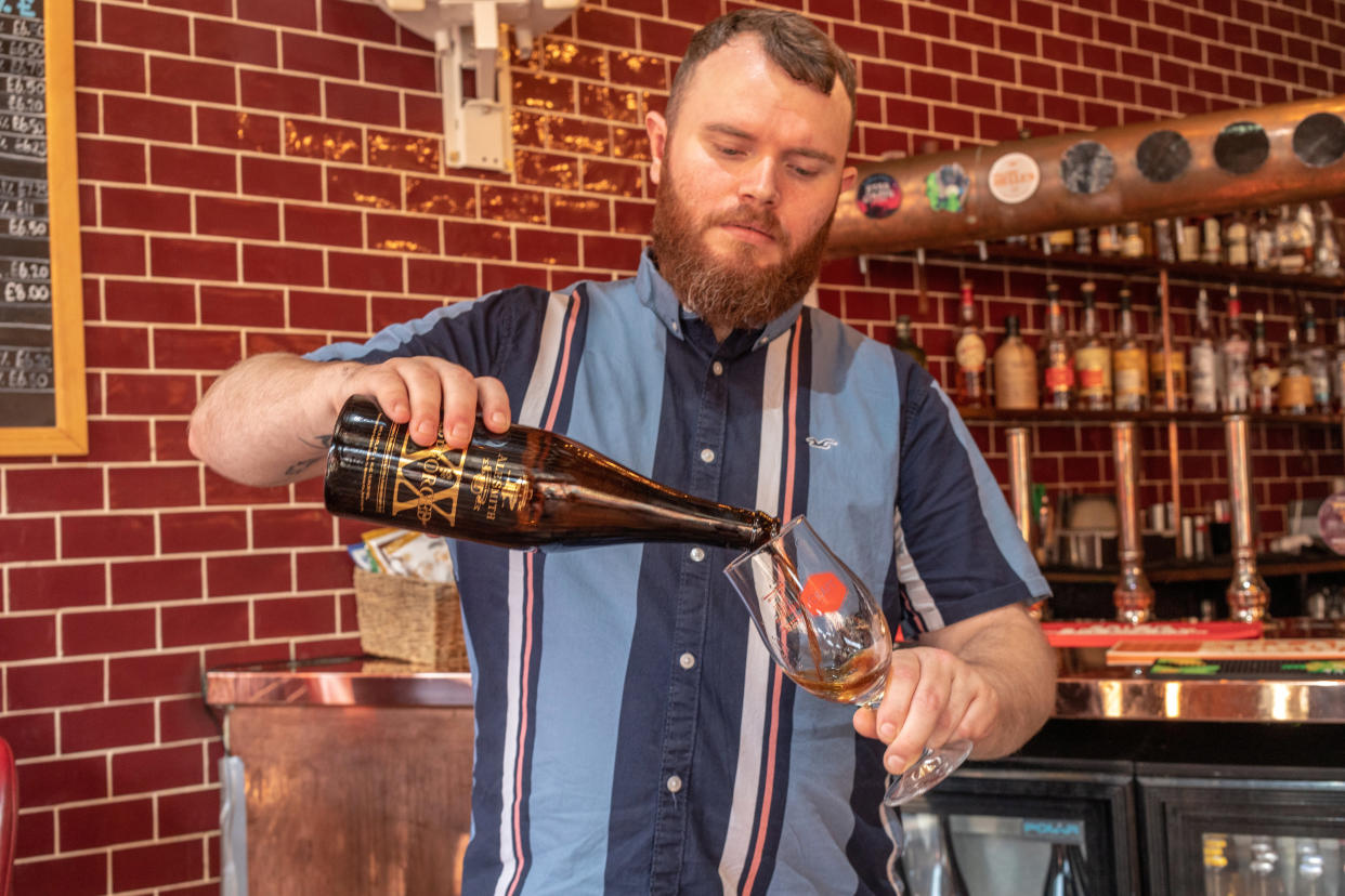 A barman pours a bottle of Reforged by Alesmith, the most expensive beer in London. (SWNS)