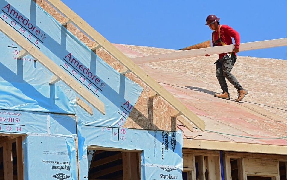 A roofer is seen working on a condominium in Canterbury Crossing on a hot day in Latham, N.Y.