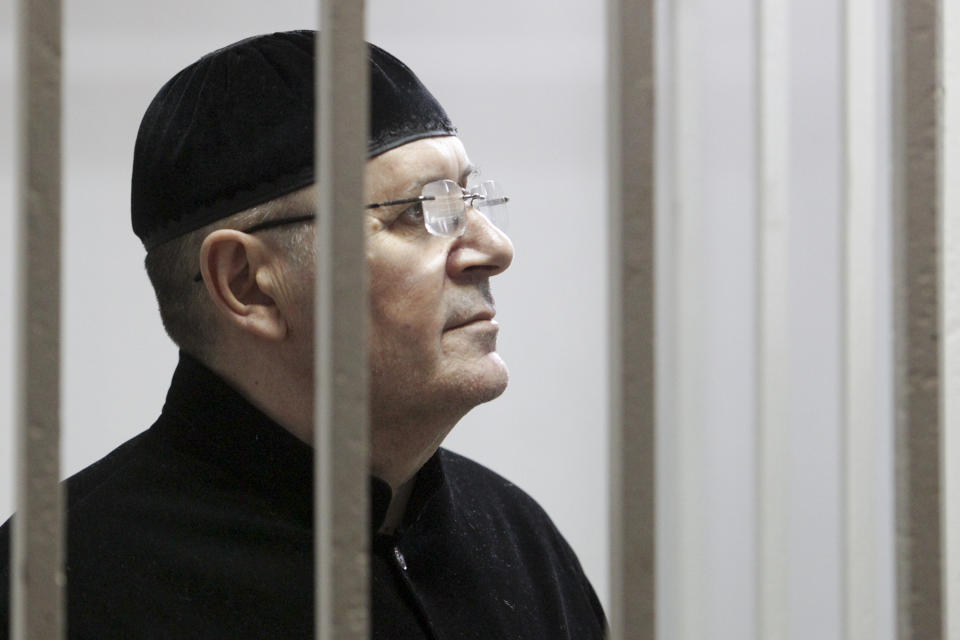Oyub Titiev, the head of a Chechnya branch of the prominent human rights group Memorial, stands behind bars in court before a hearing in Shali, Russia, Monday, March 18, 2019. Oyub Titiyev was detained in January 2018 and charged with drug possession in what has been largely perceived as a vendetta against this rare critic of the Chechen government. The court is due to issue its verdict Monday. (AP Photo/Musa Sadulayev)