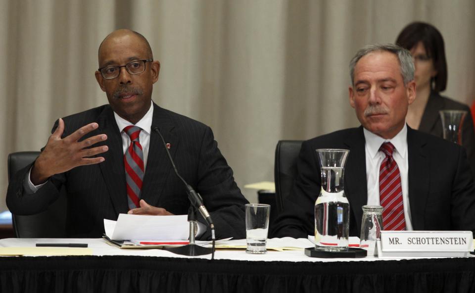 Dr. Michael Drake, left, the incoming president at Ohio State University, speaks during the university board meeting after being voted in as president as Robert Schottenstein, board chairman, looks on Wednesday, Jan. 30, 2014. (AP Photo/Paul Vernon)