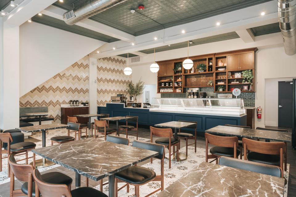 The 2,400 square foot bakery has a modern design with warm earth tones, brass accent lighting, and a refurbished, original 14-foot 1930s art-deco tin ceiling.