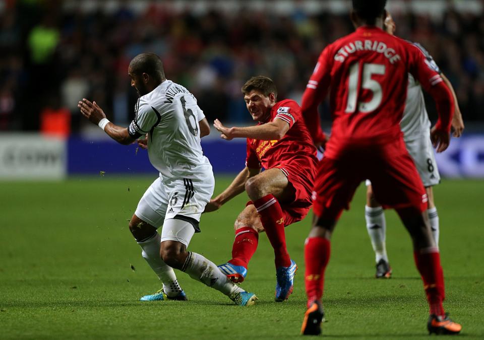 Liverpool's Steven Gerrard (centre) and Swansea City's Ashley Williams battle for the ball