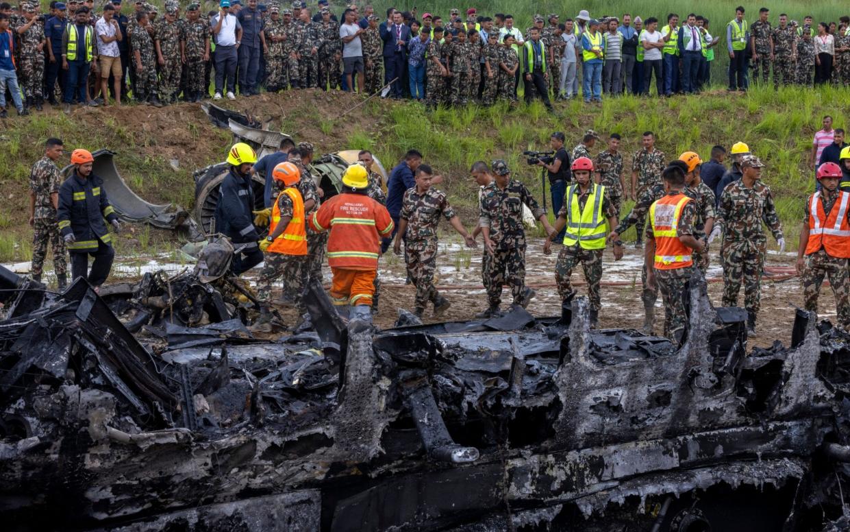 Rescue teams at the crash site where 18 people were killed