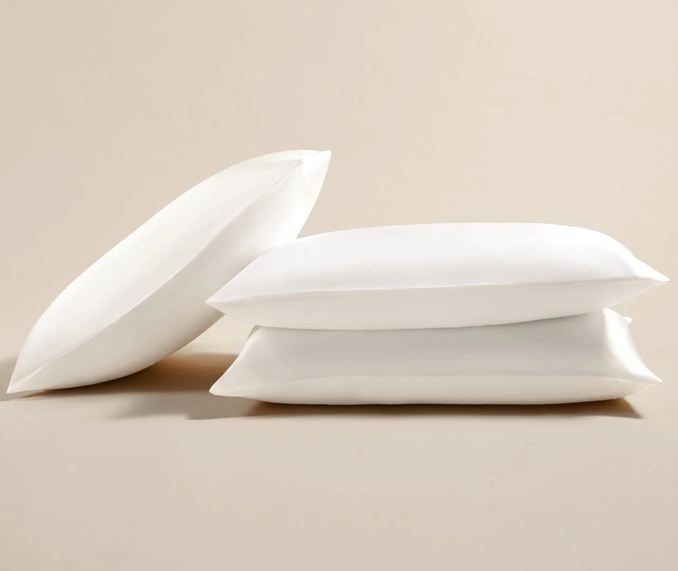 three pillows with white silk pillowcases