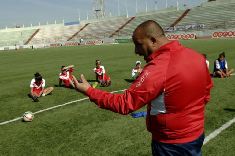 Coach Sid Ahmed Mouaz (R) instructs his players during a training session in the Algerian city of Relizane