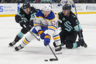Buffalo Sabres left wing Jeff Skinner (53) reaches for the puck while pursued by Seattle Kraken right wing Eeli Tolvanen, left, and defenseman Will Borgen, right, during the second period of an NHL hockey game Monday, March 18, 2024, in Seattle. (AP Photo/Lindsey Wasson)