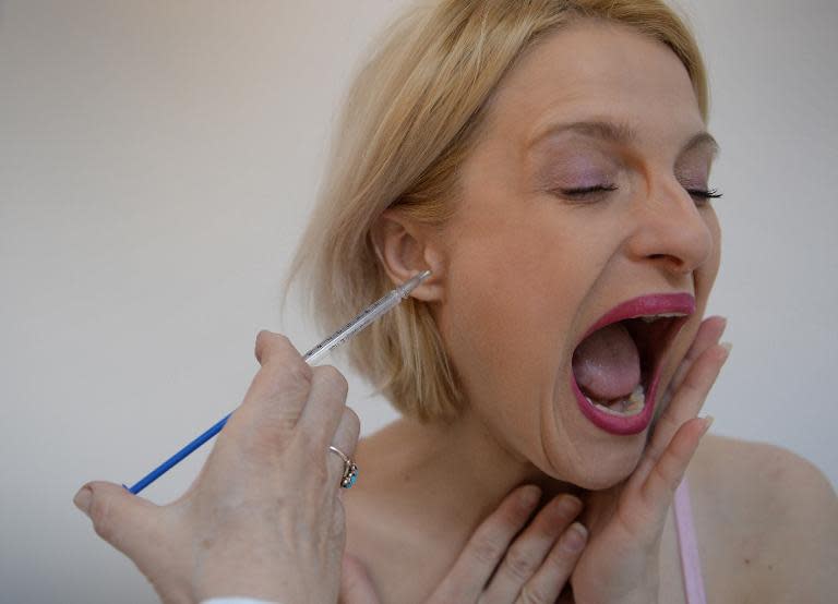 Doina Postolachi, 34, receives bee venom treatment at a medical center in Bucharest, on March 28, 2014