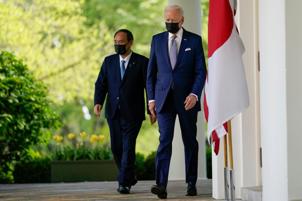 President Joe Biden, accompanied by Japanese Prime Minister Yoshihide Suga, walks from the Oval Office to speak at a news conference in the Rose Garden of the White House, Friday, April 16, 2021, in Washington.