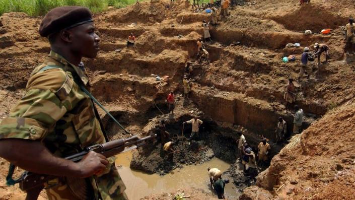 UPC soldier overlooking labourers in gold mine in 2002