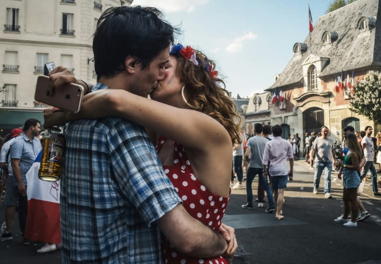 A couple kissed Sunday outside the Carillon bar in Paris, one of several targeted by jihadist gunmen in November 2015 in attacks which killed 130 people