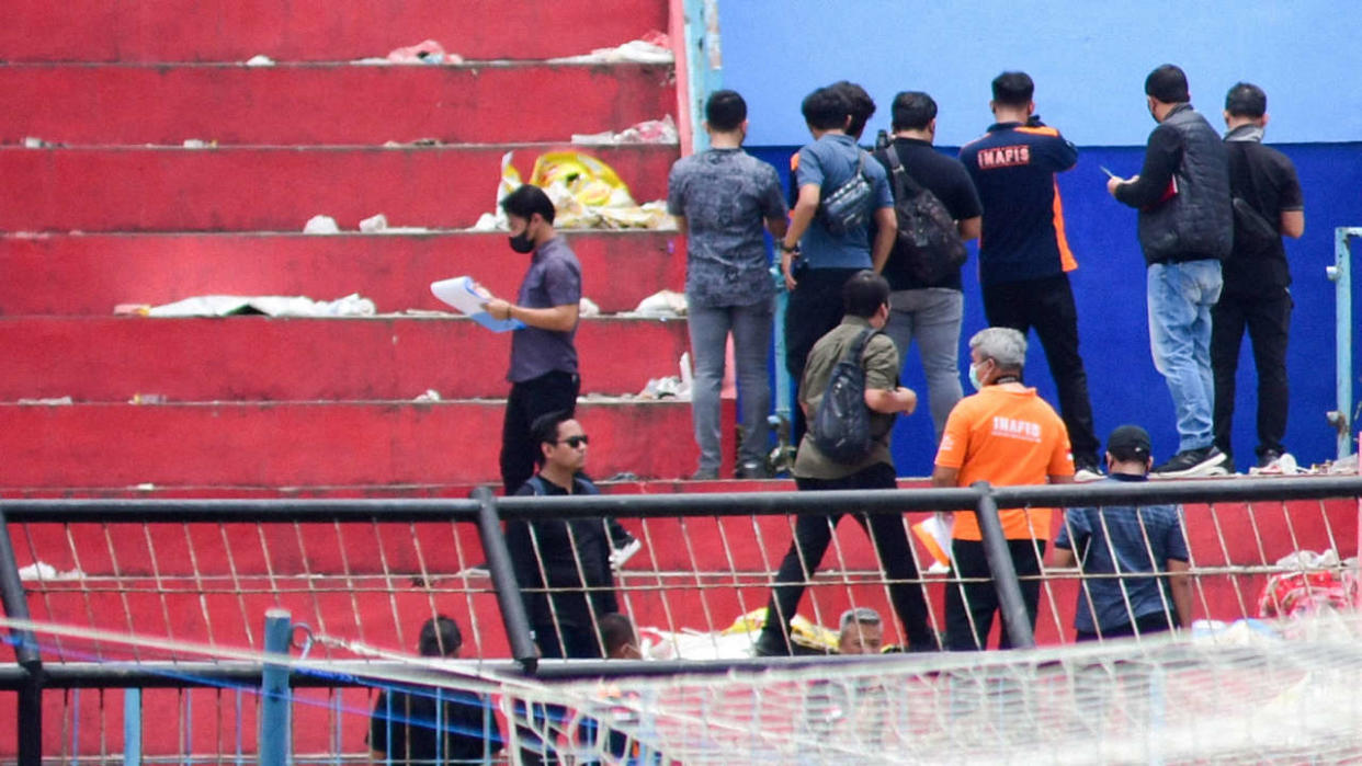 Cette photo prise le 13 octobre 2022 montre la police indonésienne enquêtant au stade Kanjuruhan à Malang, à la suite d’une bousculade qui a tué au moins 133 personnes dans l’une des catastrophes les plus meurtrières de l’histoire du football.