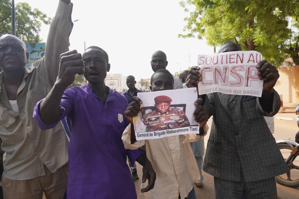 Nigeriens participate in a march called by supporters of coup leader Gen. Abdourahmane Tchiani, seen in picture, in Niamey, Niger, Sunday, July 30, 2023. Days after after mutinous soldiers ousted Niger's democratically elected president, uncertainty is mounting about the country's future and some are calling out the junta's reasons for seizing control. (AP Photo/Sam Mednick)