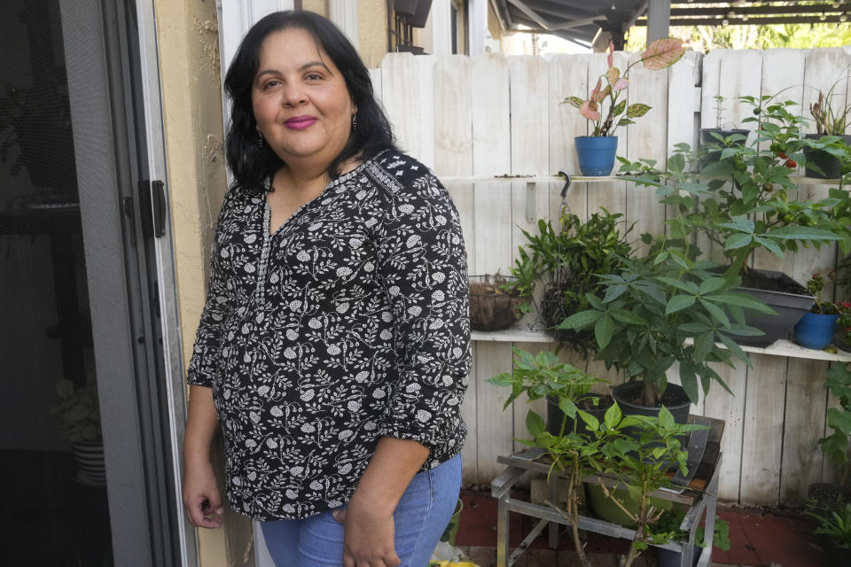 Lorena García, from Venezuela, poses for a portrait in the patio of her home in Doral, Florida, Thursday, Feb. 23, 2023. García migrated to Miami alone in 2015 after winning the visa lottery and became a legal resident. (AP Photo/Marta Lavandier)