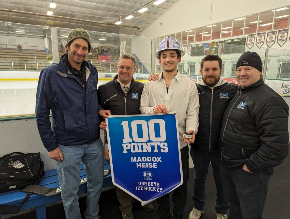 U-32's Maddox Heise, center, poses with assistant coach Roy Schiff, left, head coach Shane Locke, and assistant coaches Corey Robbins and Corey Gillander, after Heise tallied his 100th career point in Wednesday's 4-2 high school boys hockey win at Burlington at Leddy Park.