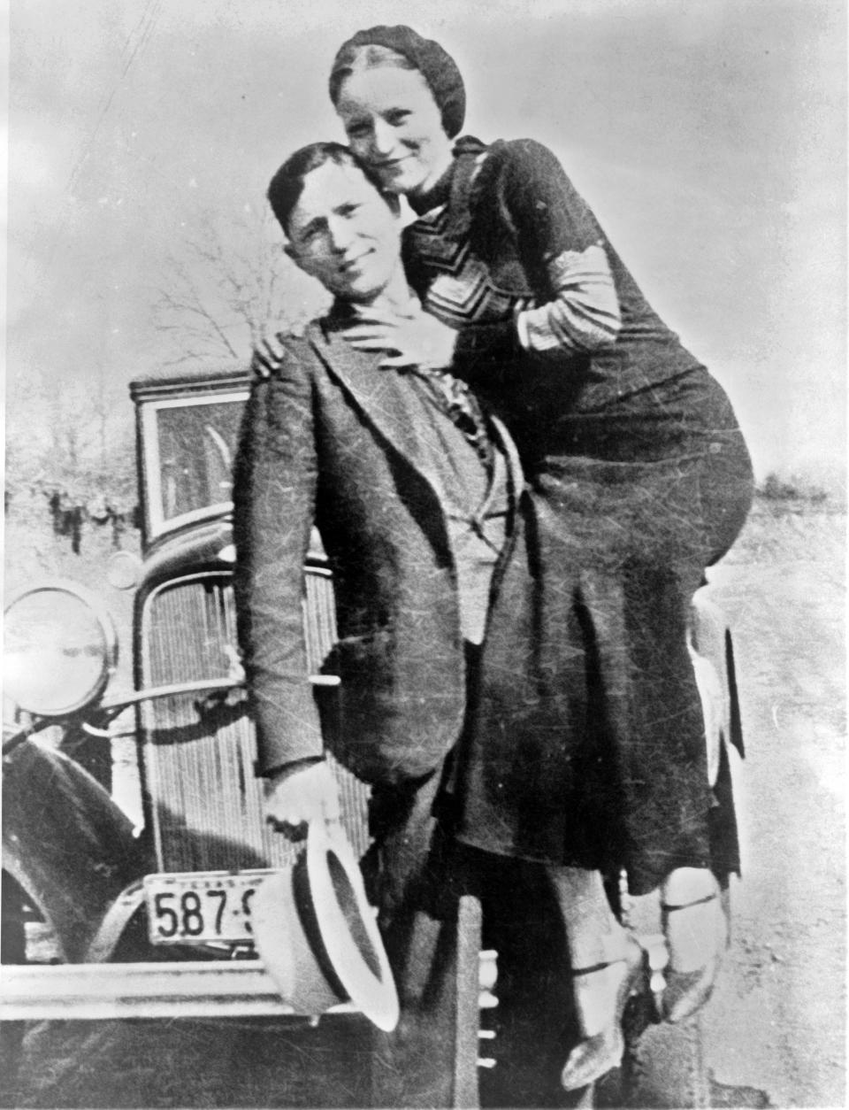 Bonnie Parker y Clyde Barrow, en algún momento entre 1932 y 1934 posando frente a un modelo de Ford V-8 de 1932. Contrario a la creencia popular, la pareja nunca se casó. (Wikimedia Commons)