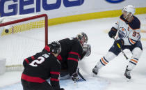 Ottawa Senators defenceman Artem Zub watches as as Edmonton Oilers center Connor McDavid scores on Senators goaltender Marcus Hogberg during the third period of an NHL hockey game Wednesday, April 7, 2021, in Ottawa, Ontario. (Adrian Wyld/The Canadian Press via AP)