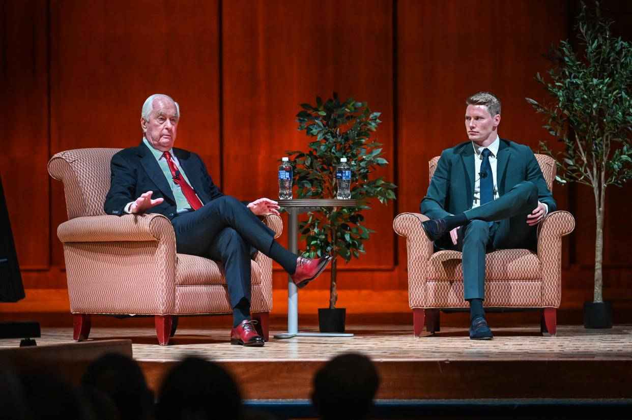 IndyCar driver Josef Newgarden, right, listens as Roger Penske, chairman of the Penske Corporation and owner of Team Penske, speaks during a “Champions of Industry” program hosted by the Sullivan School of Business and Technology on Tuesday, April 16, 2024, at Carroll University in Waukesha, Wisconsin.