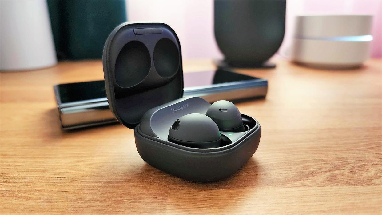  Samsung Galaxy Buds 2 Pro with phone on a table top lifestyle. 