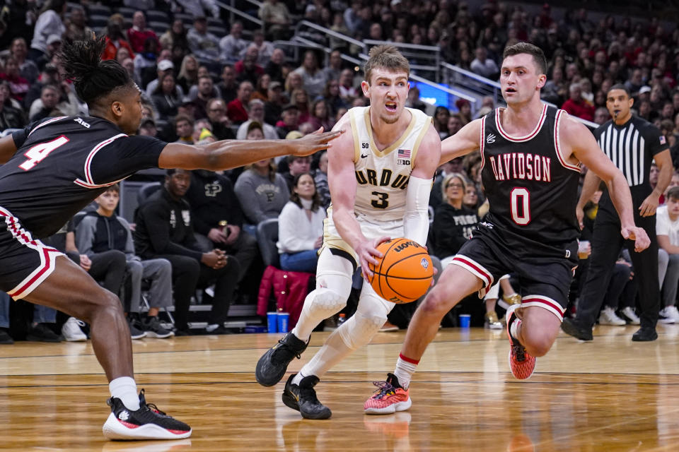 Purdue guard Braden Smith (3) drives between Davidson guard Desmond Watson (4) and guard Foster Loyer (0) in the first half of an NCAA college basketball game in Indianapolis, Saturday, Dec. 17, 2022. (AP Photo/Michael Conroy)