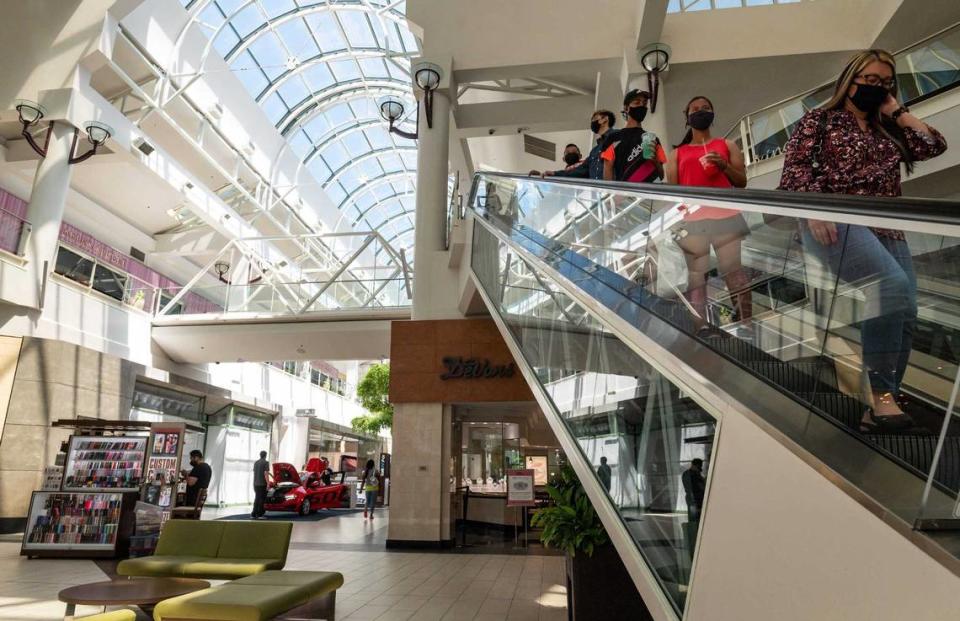 Shoppers descend the escalator at Arden Fair mall in 2021.