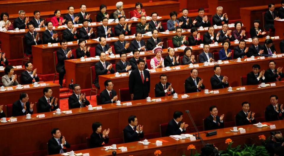 Chinese President Xi Jinping (second row C) stands at the National People’s Congress in the Great Hall of the People in Beijing.