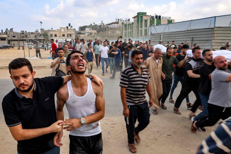 Un grupo de personas lleva los cuerpos de una familia palestina asesinada en un ataque aéreo israelí a su entierro en un cementerio en Khan Yunis, en el sur de la Franja de Gaza, el 11 de octubre de 2023. 