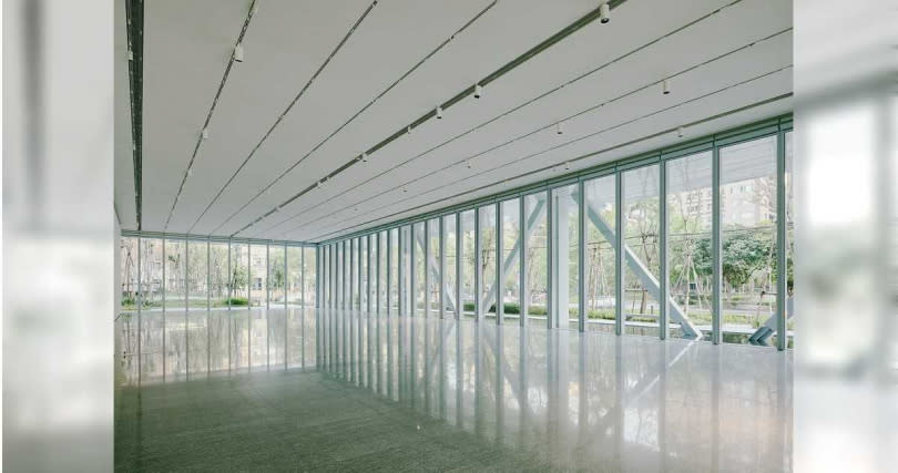 富邦美術館一樓「水景展廳」挑高六米、無立柱阻隔，三面玻璃帷幕設計使其具備穿透與輕盈，與戶外的自然植層和淺水池面相互映射流動，展現視覺連接與開闊的展場空間。（圖／富邦美術館提供）