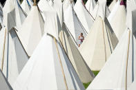 <p>A reveller walks among the tipi tents at the Glastonbury Festival of Music and Performing Arts on Worthy Farm near the village of Pilton in Somerset, South West England, on June 21, 2017. (Photo: Oli Scarff/AFP/Getty Images) </p>