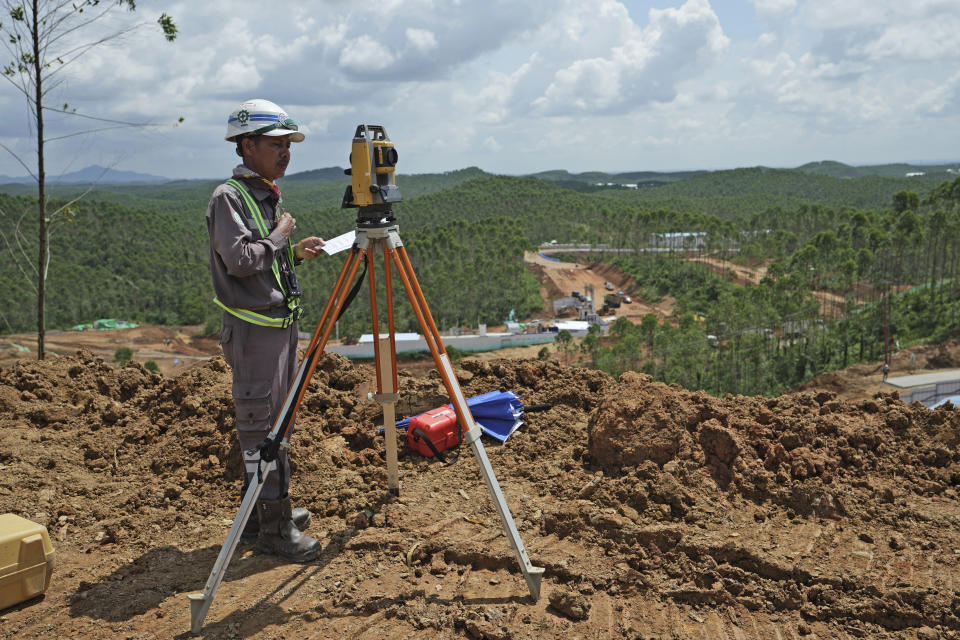 Worker uses his equipment at the construction site of the new capital city in Penajam Paser Utara, East Kalimantan, Indonesia, Wednesday, March 8, 2023. Indonesia began construction of the new capital in mid 2022, after President Joko Widodo announced that Jakarta — the congested, polluted current capital that is prone to earthquakes and rapidly sinking into the Java Sea — would be retired from capital status. (AP Photo/Achmad Ibrahim)