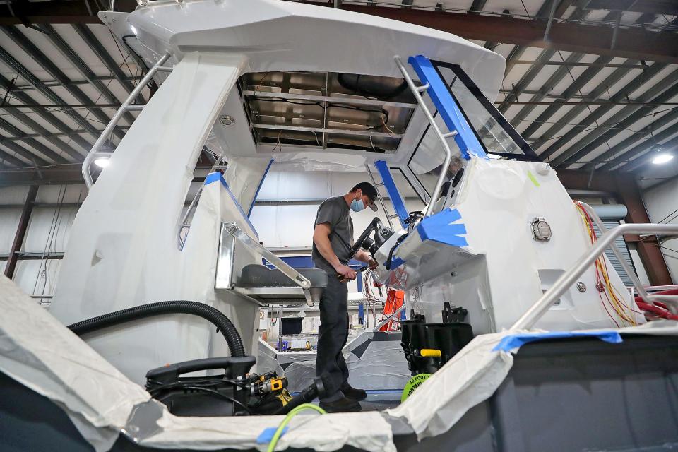 Scott Crabb wires up a toggle bank on a 23ft Center Console boat at Inventech Marine Solutions in Bremerton in this Oct. 13, 2021 file photo. The company plans to expand its services as it's building a 60,000-square-foot manufacturing facility west of the Bremerton National Airport.
