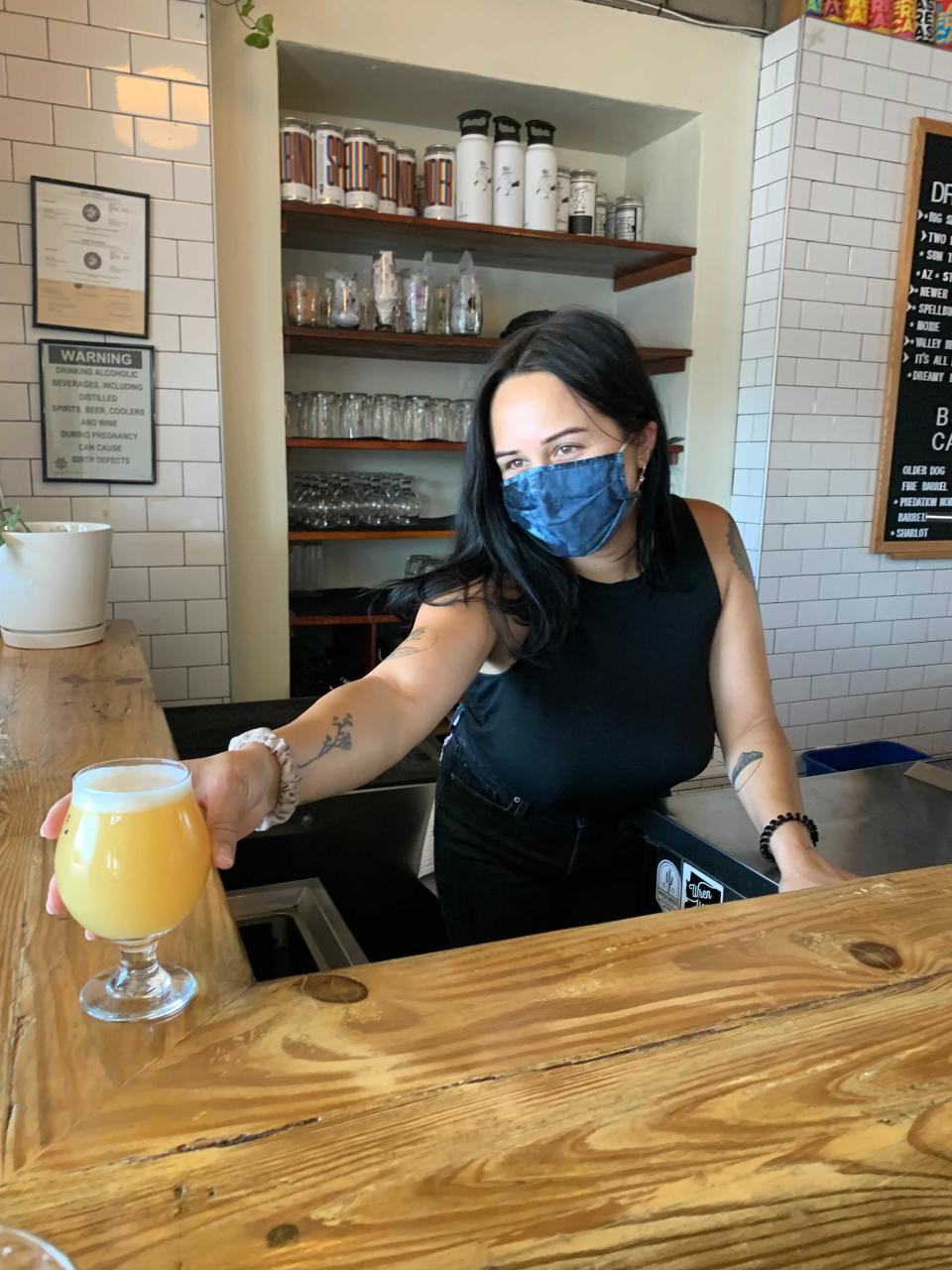 Miranda Gonsalez, taproom associate, Wren House Brewing Co. serves a drink.