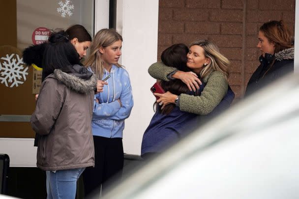 PHOTO: A parent hugs a child as other come to pick up students from the Meijer store in Oxford following an active shooter situation at Oxford High School in Oxford, Mich., Nov. 30, 2021.   (Ryan Garza/Detroit Free Press via USA Today Network)