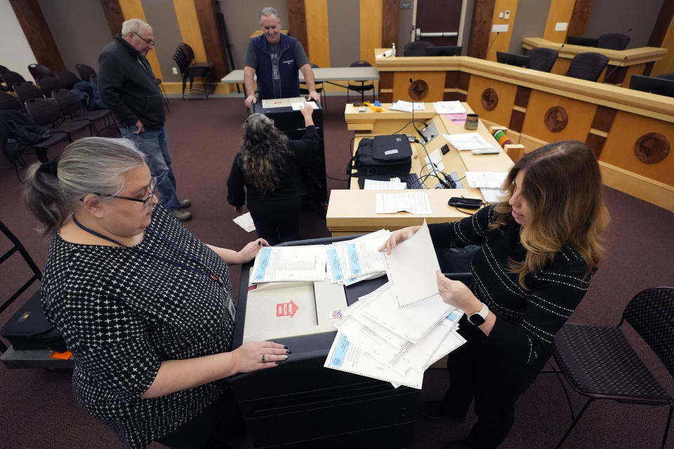 Tina Guilford, town clerk of Derry, N.H., and deputy town clerk Lynne Gagnon prepare sample ballots while testing vote-counting machines.