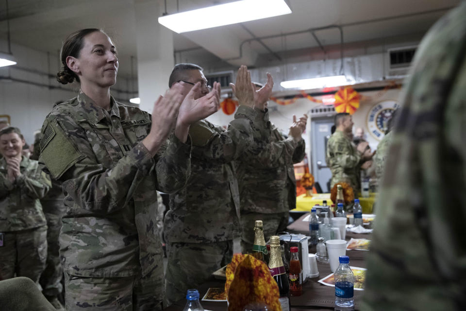 Members of the military applaud as President Donald Trump speaks at a dinning facility during a surprise Thanksgiving Day visit, Thursday, Nov. 28, 2019, at Bagram Air Field, Afghanistan. (AP Photo/Alex Brandon)