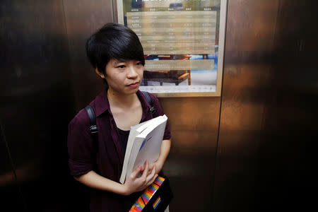 Qiu Bai, a Chinese student who lodged a suit against the Ministry of Education over school textbooks describing homosexuality as a mental disorder, holds the textbooks she refers to before going to the court in Beijing, China September 12, 2016. REUTERS/Damir Sagolj