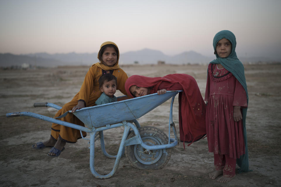 FILE - In this Monday, Sept. 13, 2021 file photo, children pose for a photo as they play in a camp for internally displaced people in Kabul, Afghanistan. A month after the fall of Kabul, the question of how the world will get aid to citizens without enriching Afghanistan's Taliban rulers is haunting the country. The stakes have soared for Afghans, who along with the threat of famine and a collapsing health care system face a looming crisis as winter approaches. (AP Photo/Felipe Dana, File)