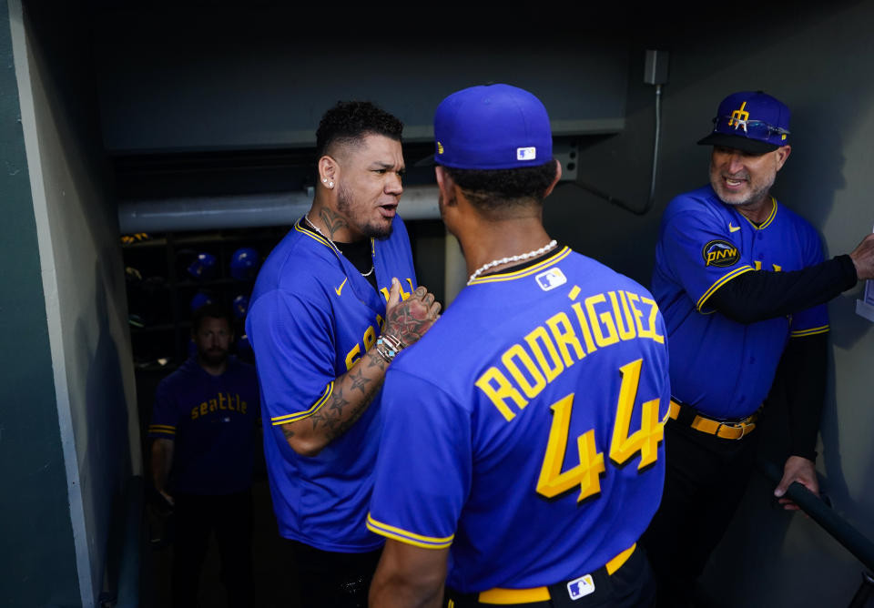 Former Seattle Mariners pitcher Felix Hernandez, left, grets center fielder Julio Rodríguez (44) before a baseball game between the Mariners and the Baltimore Orioles, Friday, Aug. 11, 2023, in Seattle. (AP Photo/Lindsey Wasson)