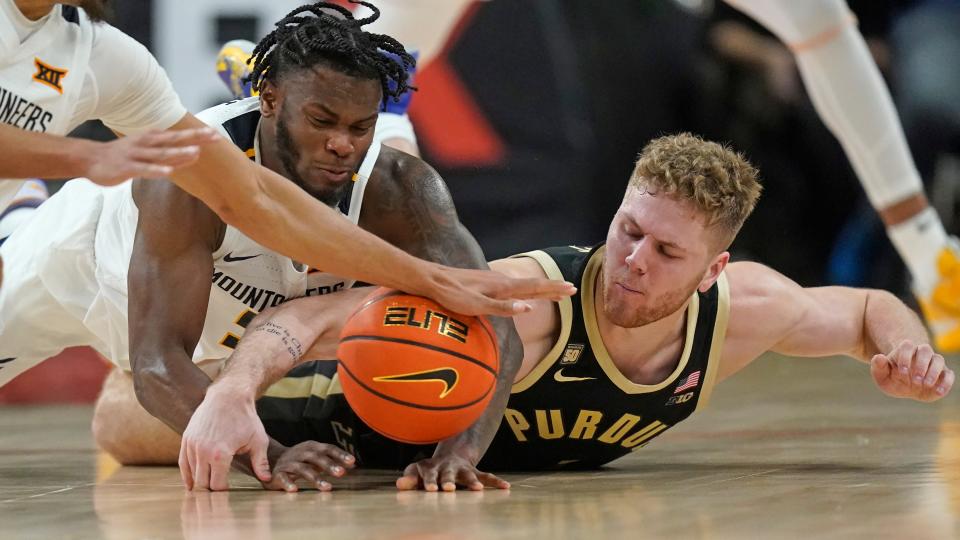 West Virginia guard Joe Toussaint, left, and Purdue forward Caleb Furst, right, battle for a loose ball during the second half of an NCAA college basketball game in the Phil Knight Legacy tournament Thursday, Nov. 24, 2022, in Portland, Ore. (AP Photo/Rick Bowmer)
